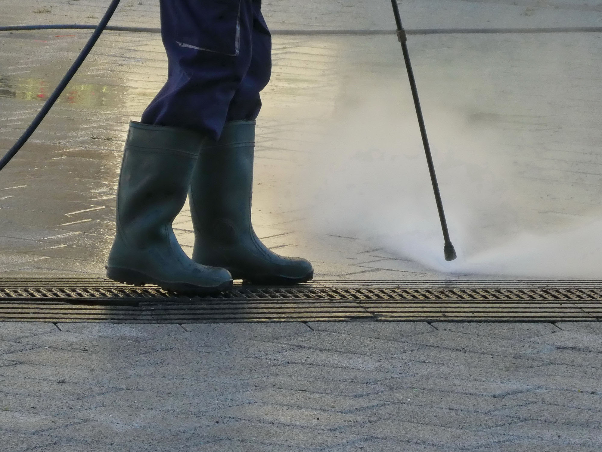 dreamstime_m_188954166 Man steam cleaning street with pressure outdoor